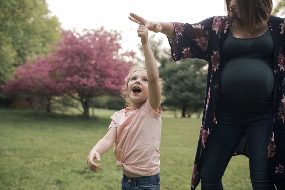 Maternity Photographer Rochester NY, little girl dancing with her mom in a Spring field